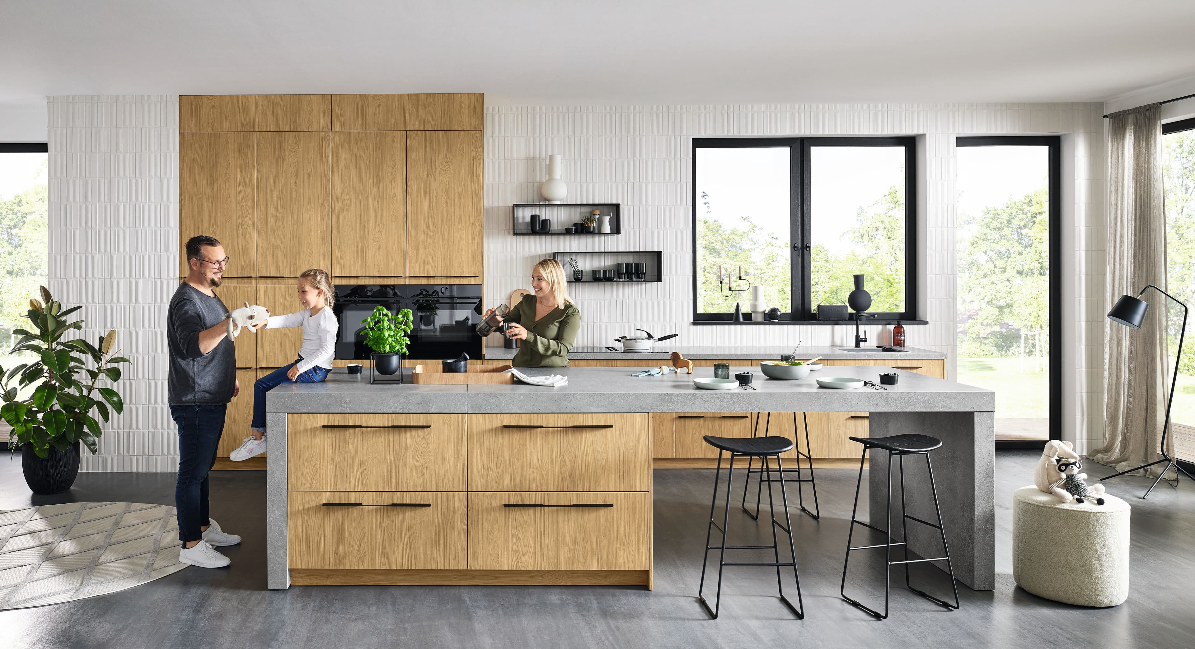 Helle Nolte Küche mit Eiche-Fronten und Insel in Beton-Optik, Familie beim Kochen
