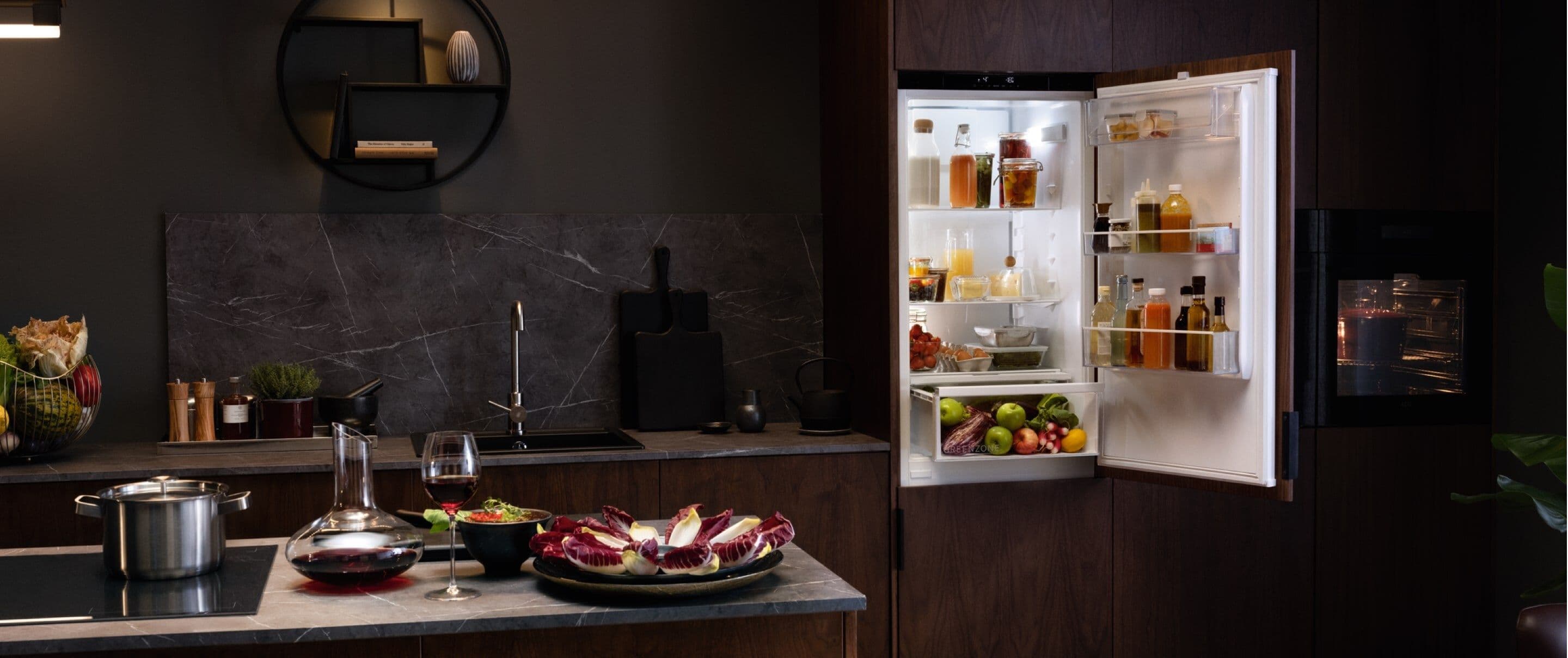 AEG Kühlschrank offen in Wohnküche dunkel mit Marmor-Backsplash und Wein-Stillleben, Premium-Architektur